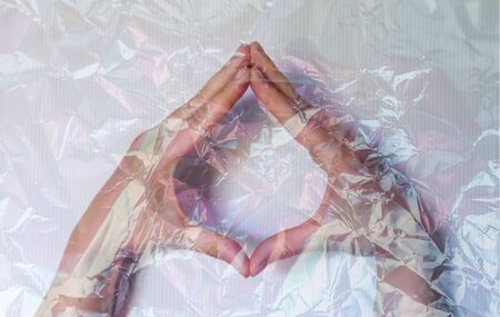 Hand of a young female wrapped in plastic film showing different symbols