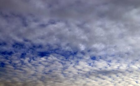 Stunning mixed cloud formation panorama in a deep blue summer sky.