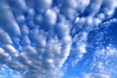 Stunning mixed cloud formation panorama in a deep blue summer sky.