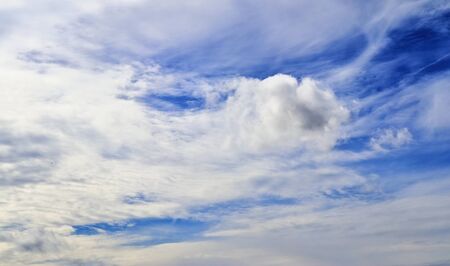 Stunning mixed cloud formation panorama in a deep blue summer sky.