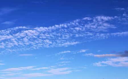 Stunning mixed cloud formation panorama in a deep blue summer sky.