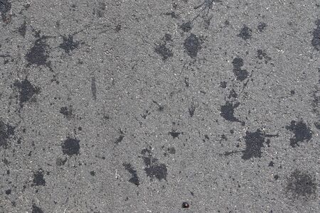 Detailed view on asphalt surfaces of different streets and roads with cracks in a close upの写真素材