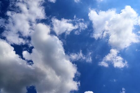 Beautiful fluffy white beautiful cloud formations in a deep blue summer sky