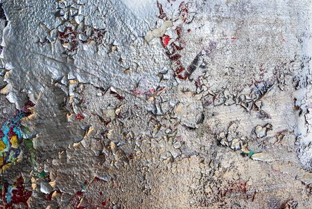Detailed and colorful close up at cracked and peeling paint on concrete wall textures in high resolution.の写真素材