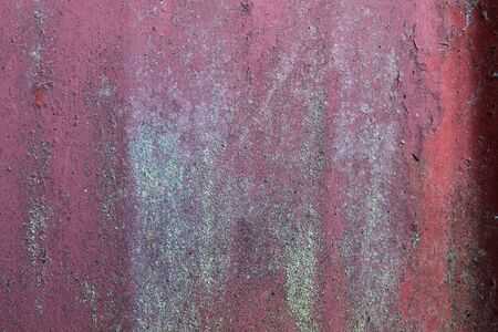 Detailed and colorful close up at cracked and peeling paint on concrete wall textures in high resolution.の写真素材