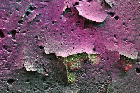 Detailed and colorful close up at cracked and peeling paint on concrete wall textures in high resolution.の写真素材