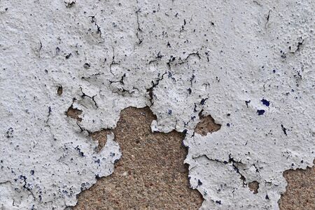 Detailed and colorful close up at cracked and peeling paint on concrete wall textures in high...