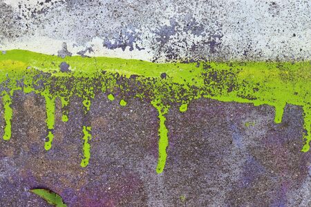 Detailed and colorful close up at cracked and peeling paint on concrete wall textures in high...