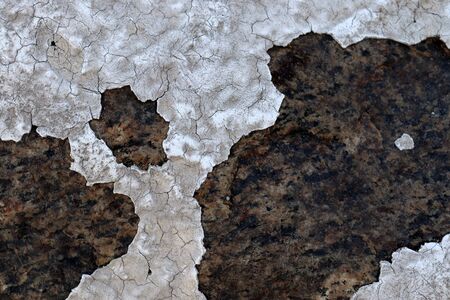 Detailed and colorful close up at cracked and peeling paint on concrete wall textures in high...