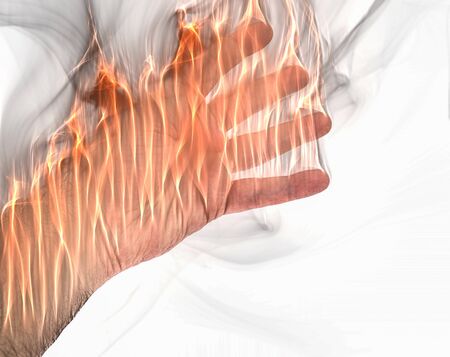 A human hand on fire burning with orange flames and some smoke in front of a white backgroundの写真素材