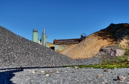 View into a gravel pit with piles of sand and tire tracks