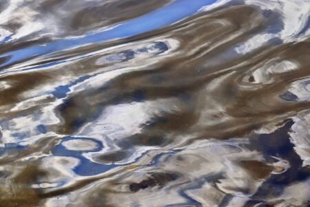 Detailed close up view on water surfaces with waves and ripples and the sunlight reflecting at the...