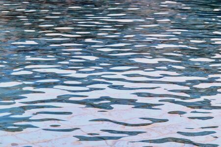 Detailed close up view on water surfaces with waves and ripples and the sunlight reflecting at the...