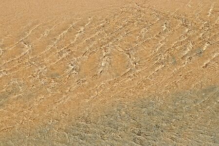 Detailed close up view on water surfaces with waves and ripples and the sunlight reflecting at the...