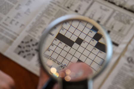 Close up view on international newspapers with a magnifying glass and a soft bokehの写真素材