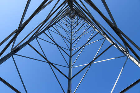 Electric antenna and communication transmitter tower in a european landscape against a blue skyの写真素材