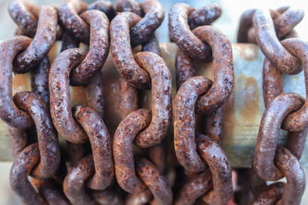 Rusty chain around metal bars at the port of Kiel