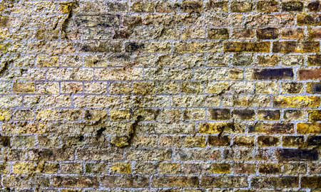 Detailed close up view on very old and weathered brick walls with cracks found in London