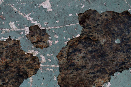 Detailed and colorful close up at cracked and peeling paint on concrete wall textures in high...