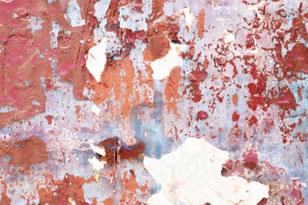 Detailed and colorful close up at cracked and peeling paint on concrete wall textures in high...