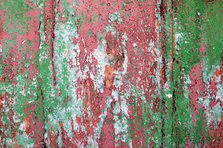 Detailed and colorful close up at cracked and peeling paint on concrete wall textures in high resolution.の写真素材