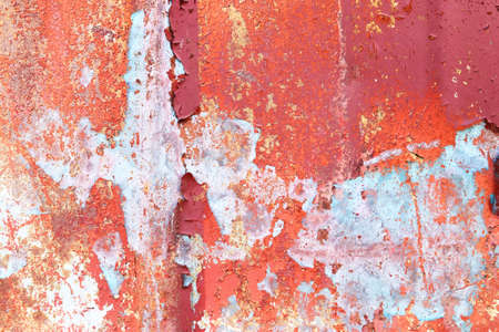 Detailed and colorful close up at cracked and peeling paint on concrete wall textures in high...