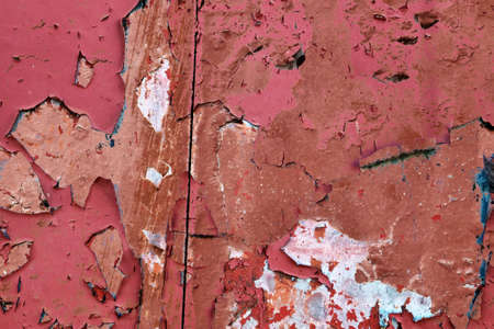Detailed and colorful close up at cracked and peeling paint on concrete wall textures in high...