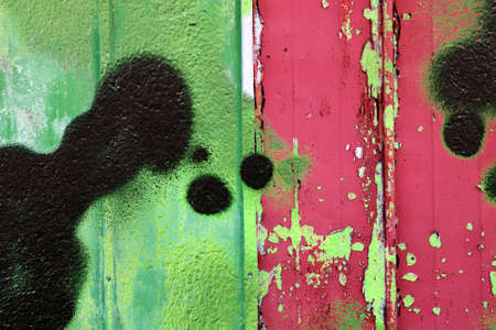 Detailed and colorful close up at cracked and peeling paint on concrete wall textures in high resolution.の写真素材
