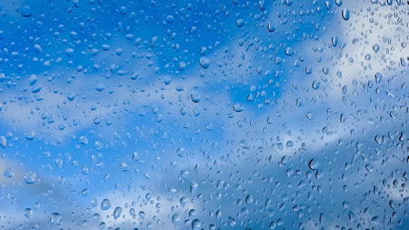 Rain drops running down a window in a close up viewの写真素材