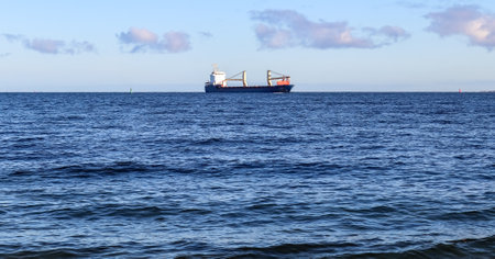Big cargo ship on the baltic sea water. View from the beach in Laboe in Germanyの写真素材