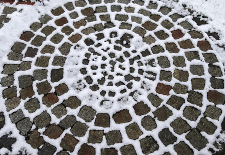 Surface of white snow on an old cobblestone way in winterの写真素材