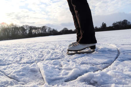 Close up on womans feet wearing ice skating boots and standing on ice