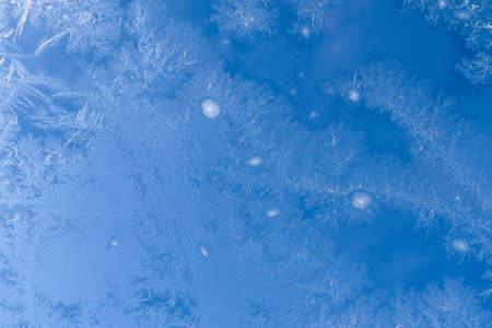 Beautiful ice flowers at a window on a cold winter day