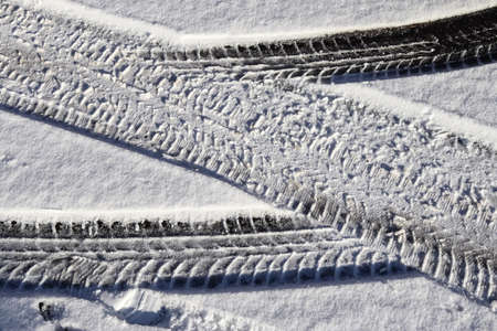 Tire Tracks on snow covered streets in a close up viewの写真素材