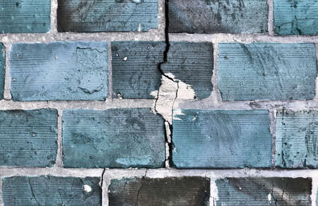 Detailed view at a colorful old and weathered brick wall texture. Panoramic background.