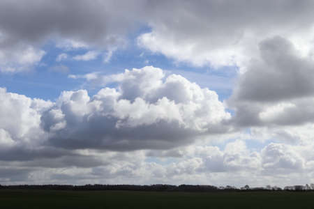 Beautiful clouds in a blue sky over a northern european landscapeの写真素材