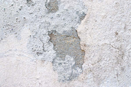 Close up view on white aged concrete walls with cracks and lots of structured details