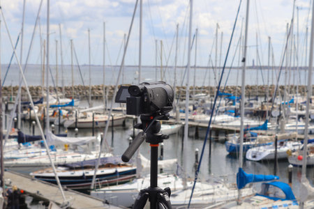 Selective focus view at a camera filming at a yacht port in Kiel in Germanyの写真素材
