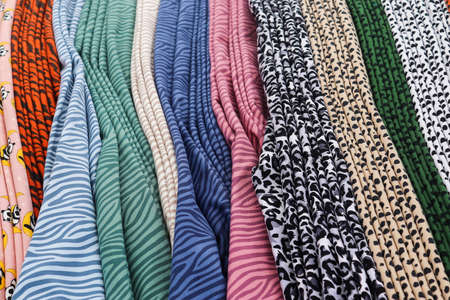 Detailed close up view on samples of cloth and fabrics in different colors found at a fabrics market.の写真素材