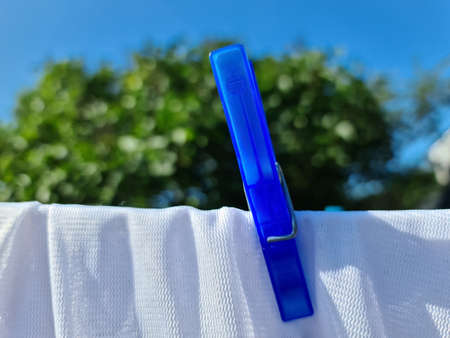 Clothes hung out on a sunny day to dry on a washing line and fastened by the clothes pegs.の写真素材