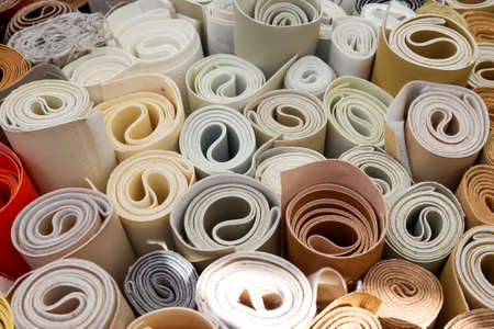 Close up view on rolled samples of cloth and fabrics in different colors found at a fabrics market.の写真素材