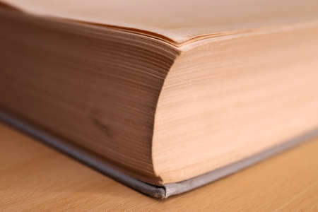 Selective focus view of an old thick german mathematics book with a male hand searching in itの写真素材