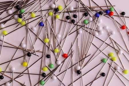 Selective focus of many pins with coloured glass heads on a white backgroundの写真素材