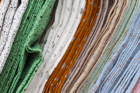 Detailed close up view on samples of cloth and fabrics in different colors found at a fabrics market.の写真素材