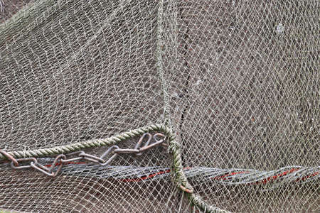 Close up view on a fishing net decoration on an old weathered wall