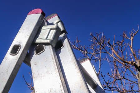 The top of an aluminum ladder against blue skyの写真素材