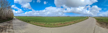 Panorama of a northern european country landscape with fields and green grass.