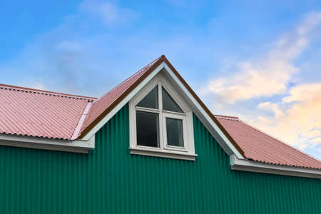Roof window in velux style with roof tiles - icelandic architectureの写真素材