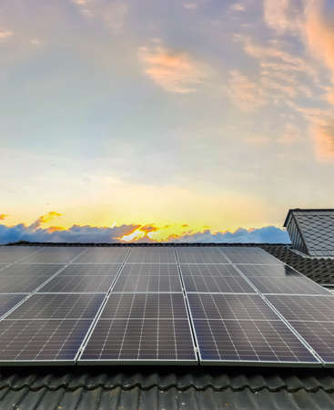 Solar panels producing clean energy on a roof of a residential houseの写真素材