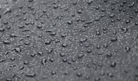 Rain drops on a black metallic surface in a closeup viewの写真素材